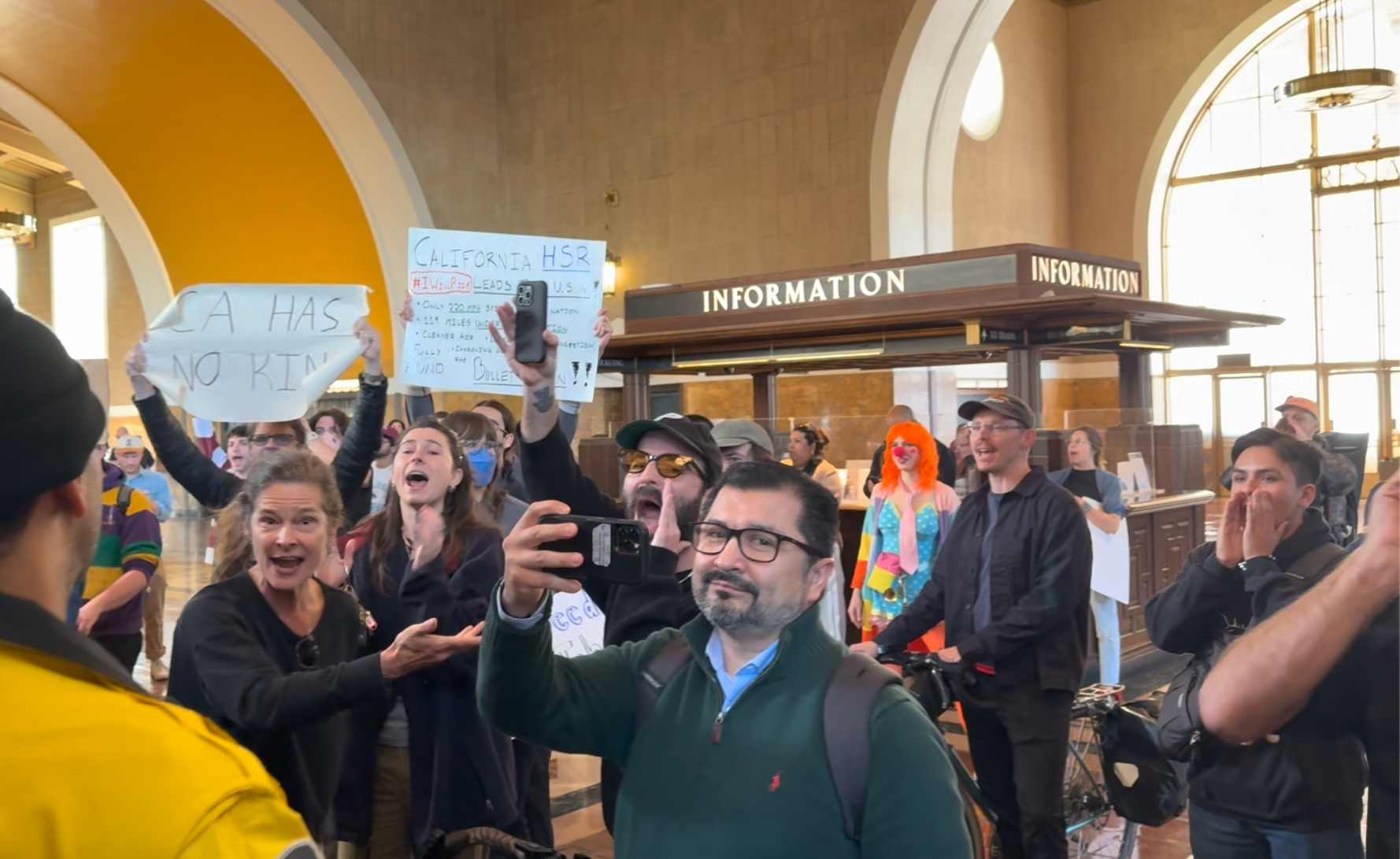 Protesters in Union Station holding signs that say "CA has no king"