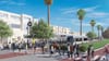 A rendering for the Vermont Corridor Bus Rapid Transit project showing dozens of people crossing a street to a beautiful bus