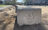 A concrete bench stamped with the 1984 Olympics logo lined up with other benches in Expo Park.