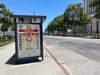 An advertisement on a bus shelter on an shadeless LA street showing "how to avoid heat stroke"