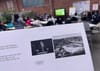 A handout showing Trump at a podium and a stadium with the Olympic rings, with a meeting happening behind