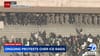 DHS and National Guard are lined up in front of protesters along the front of the federal building