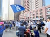 Dodger fans partying on Grand's downtown streets holding flags, buying hats, and eating hot dogs